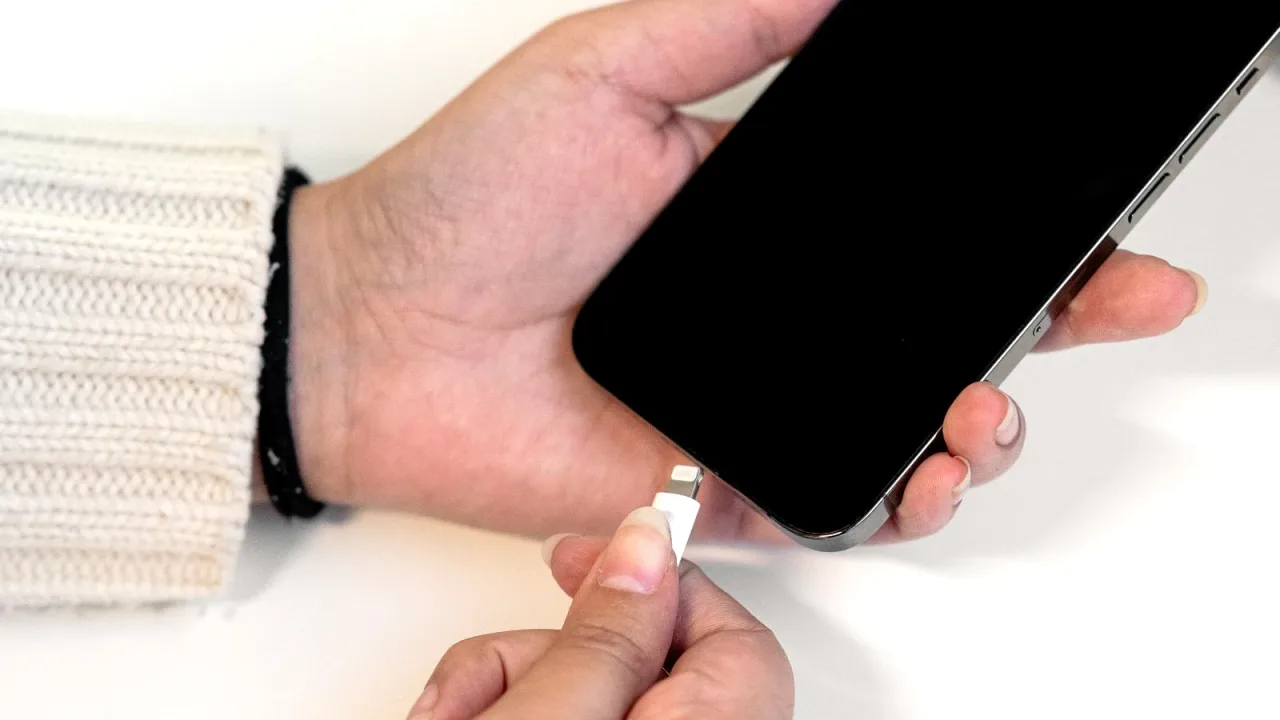 Masada telefonu şarj kablosuna takan eller