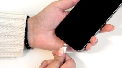 Masada telefonu şarj kablosuna takan eller